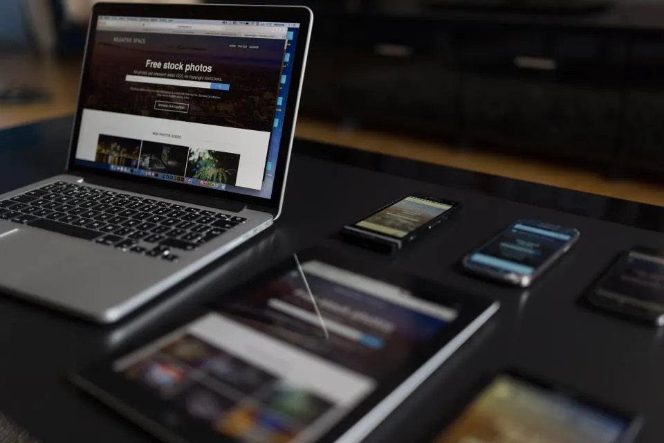 A laptop, tablet and phones displaying the same website